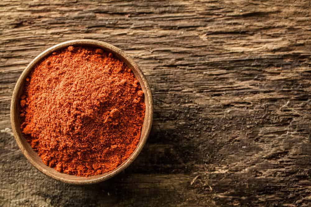 Close-up view of a bowl of ground red cayenne pepper.